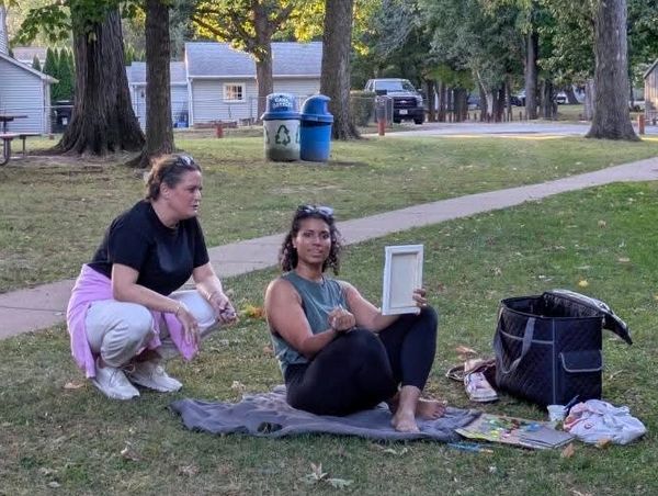 Two women outdoors with art supplies.