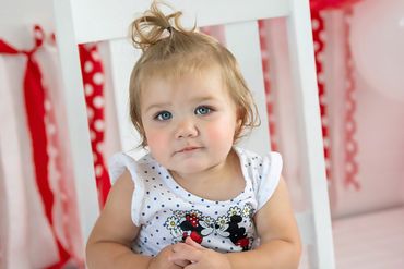 One year old posing for her new pictures during her cakesmash session
