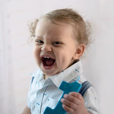 One year baby boy with a Huge smile on his face posing for his one year old cake smash photos