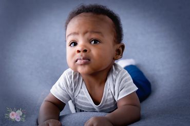 3 month old baby boy laying on bean bag on his tummy for his Milestone photos