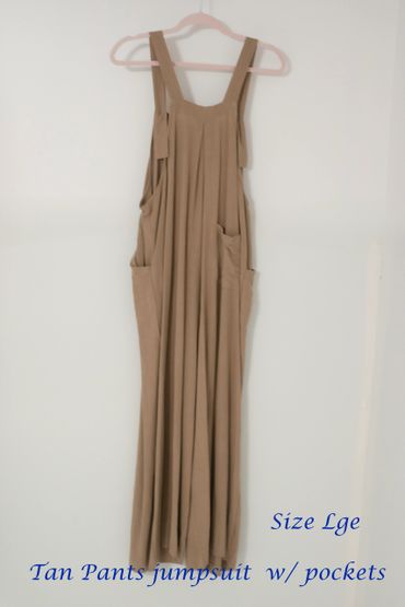 Tan pants jumpsuit with pockets, size large, hanging on a pink hanger.
