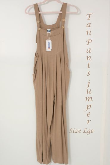 Tan-colored large size pants jumper hanging on a pink hanger.