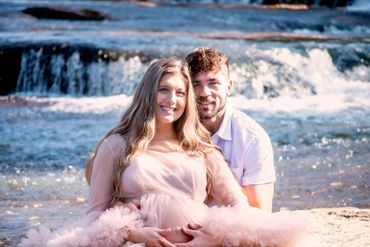 Young couple taking Maternity photos at a beautiful park