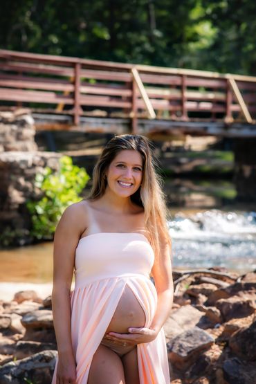 Young beautiful woman taking her Maternity photo session at Hurricane Shoals park