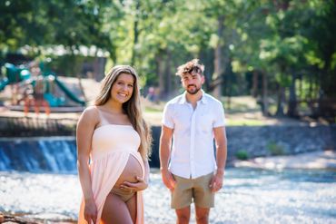 Young couple taking Maternity photos at a beautiful park Hurricane Shoals