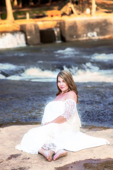beautiful woman posing for her maternity photo at Hurricane Shoals beautiful park by the water