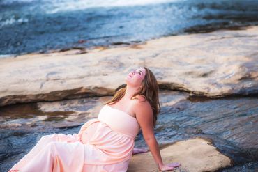beautiful woman posing for her maternity photo at a beautiful park by the water