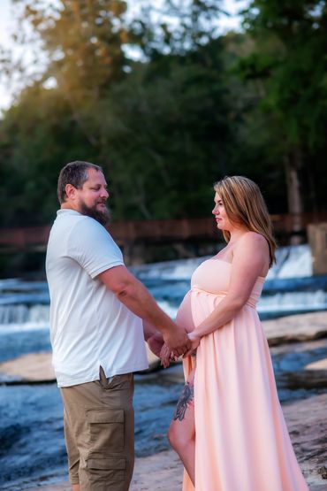 young couple posing for Maternity session at a Hurricane Shoals park