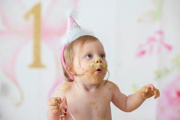 One year old with a cake messy face in her cakesmash session