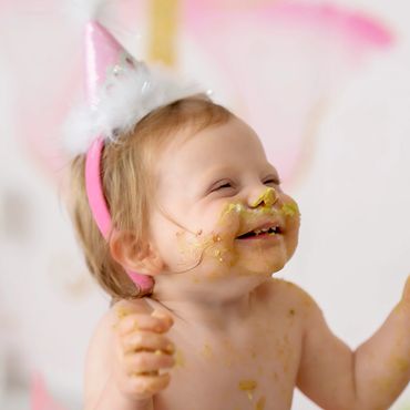 One year old with a cake messy face in her cakesmash session