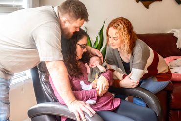in home newborn session with mommy, daddy and big sister in the livingroom
