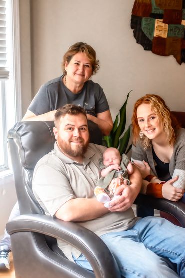 In home newborn session with grandma and dad and big sister