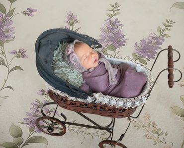 In Home Newborn session with baby wrapped in lavendar and matching bonnet laying in antique stroller