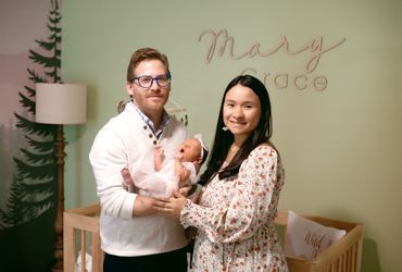 In Home Newborn session with Mom and dad in babies new room , next to her crib