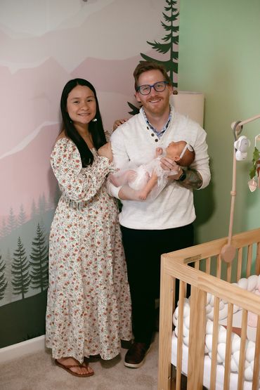 In Home Newborn session with Mom and dad in babies new room , next to her crib