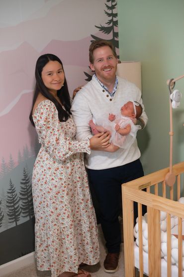 In Home Newborn session with Mom and dad in babies new room , next to her crib
