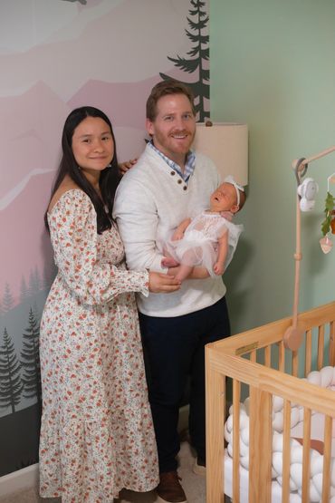 In Home Newborn session with Mom and dad in babies new room , next to her crib