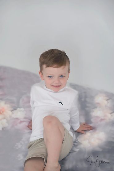 3 year old big brother posing at his baby sisters newborn photo session