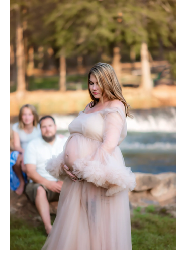 woman posing for her maternity photos while her husband and daughter look on at Hurricane Shoals