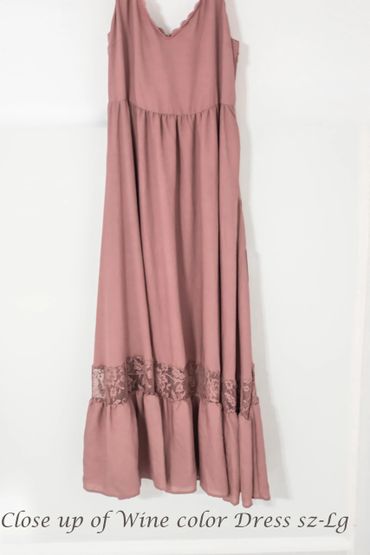 Wine-colored sleeveless dress with lace detail near the hem.