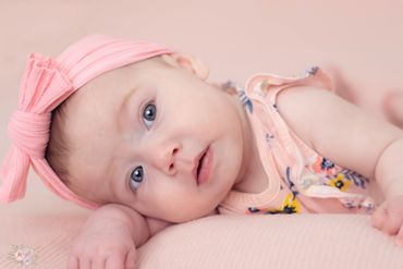 Baby girl a twin posing for her milestone photo session