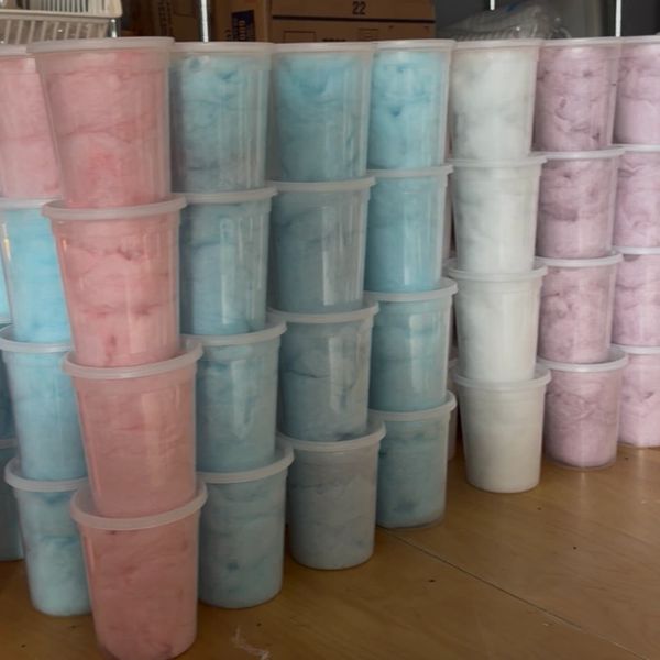 Stacks of colorful cotton candy in plastic containers.