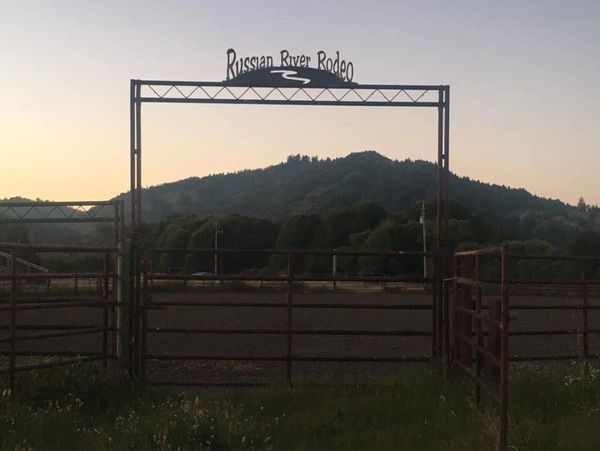 Entrance gate to the Russian River Rodeo with hills in the background at dusk.