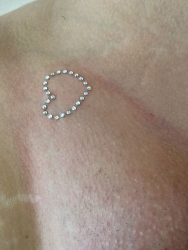 Rhinestone heart decoration on textured skin.