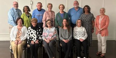 A group of elderly people posing together indoors.