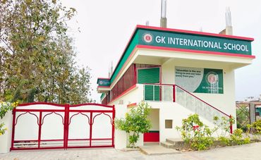 Exterior view of GK International School building with red and green accents.