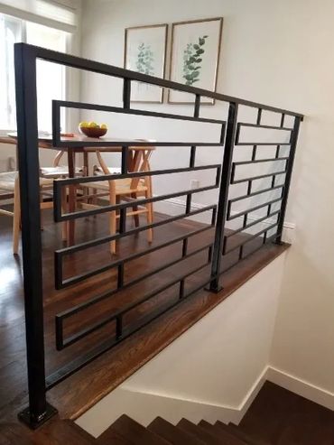 Modern black metal railing with geometric design in a cozy dining area.