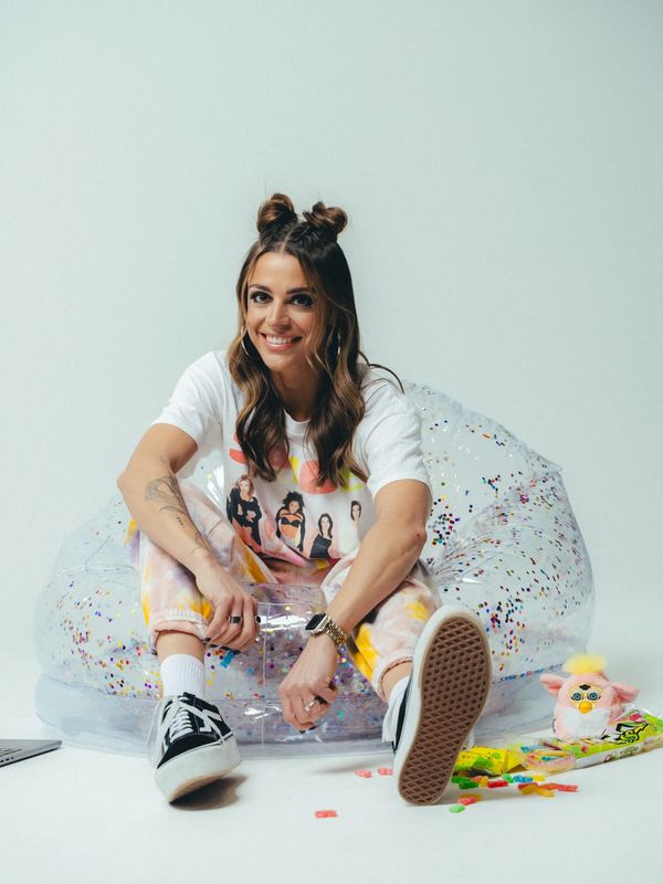Young woman sitting on a transparent inflatable chair smiling.