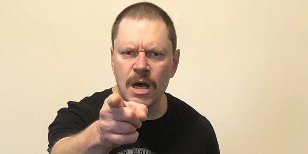 Angry man in black t-shirt pointing at camera