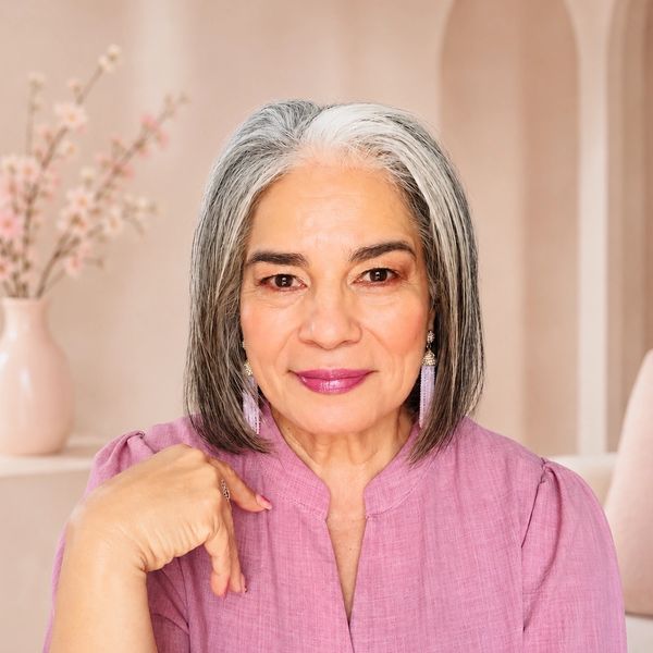 Smiling woman with gray hair in a pink blouse.
