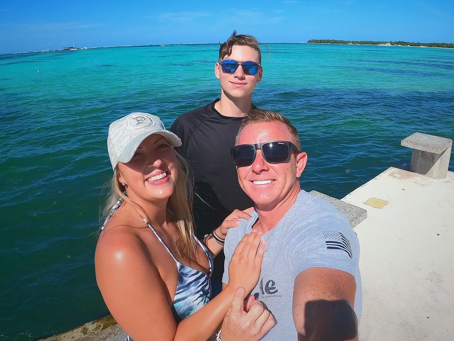 family of three standing in front of the ocean in Punta Cana