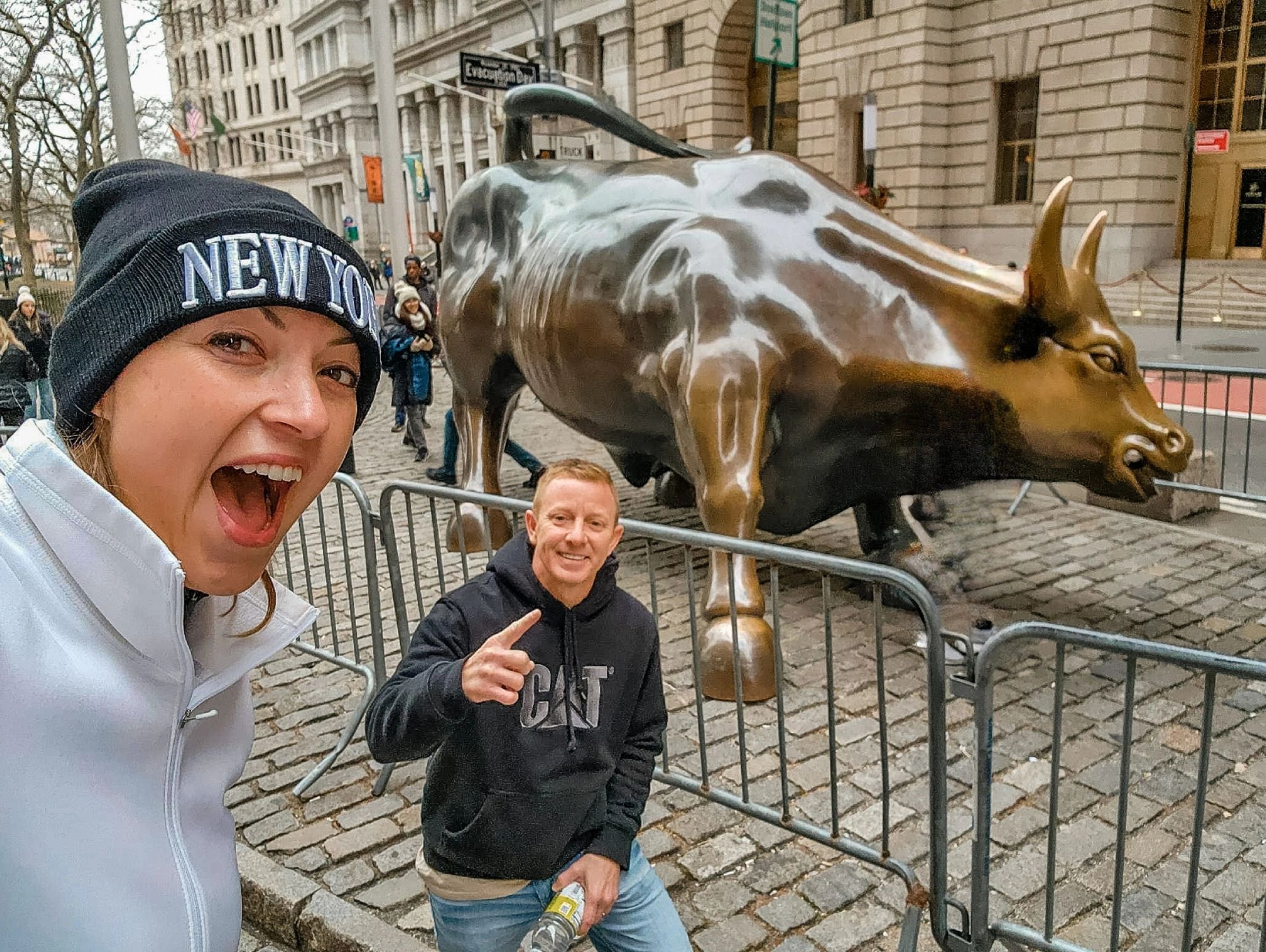 Man and Woman standing in front of the iconic Charging Bull in New York City