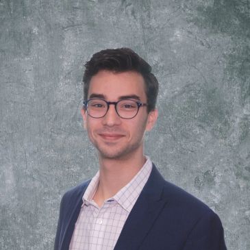 Young man wearing glasses and a suit jacket.