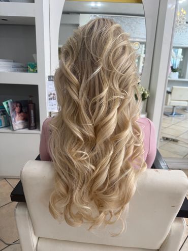 Long blonde hair styled in loose curls.