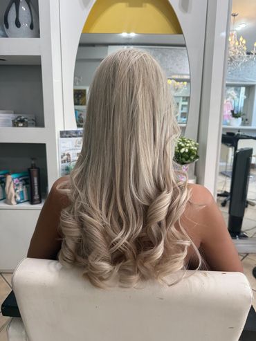 Long, curled blonde hair at a salon.