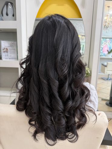 Back view of long, shiny, curly black hair.