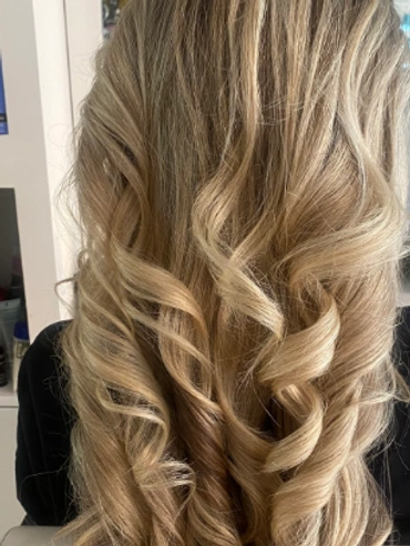 Back view of long, curly blonde hair.