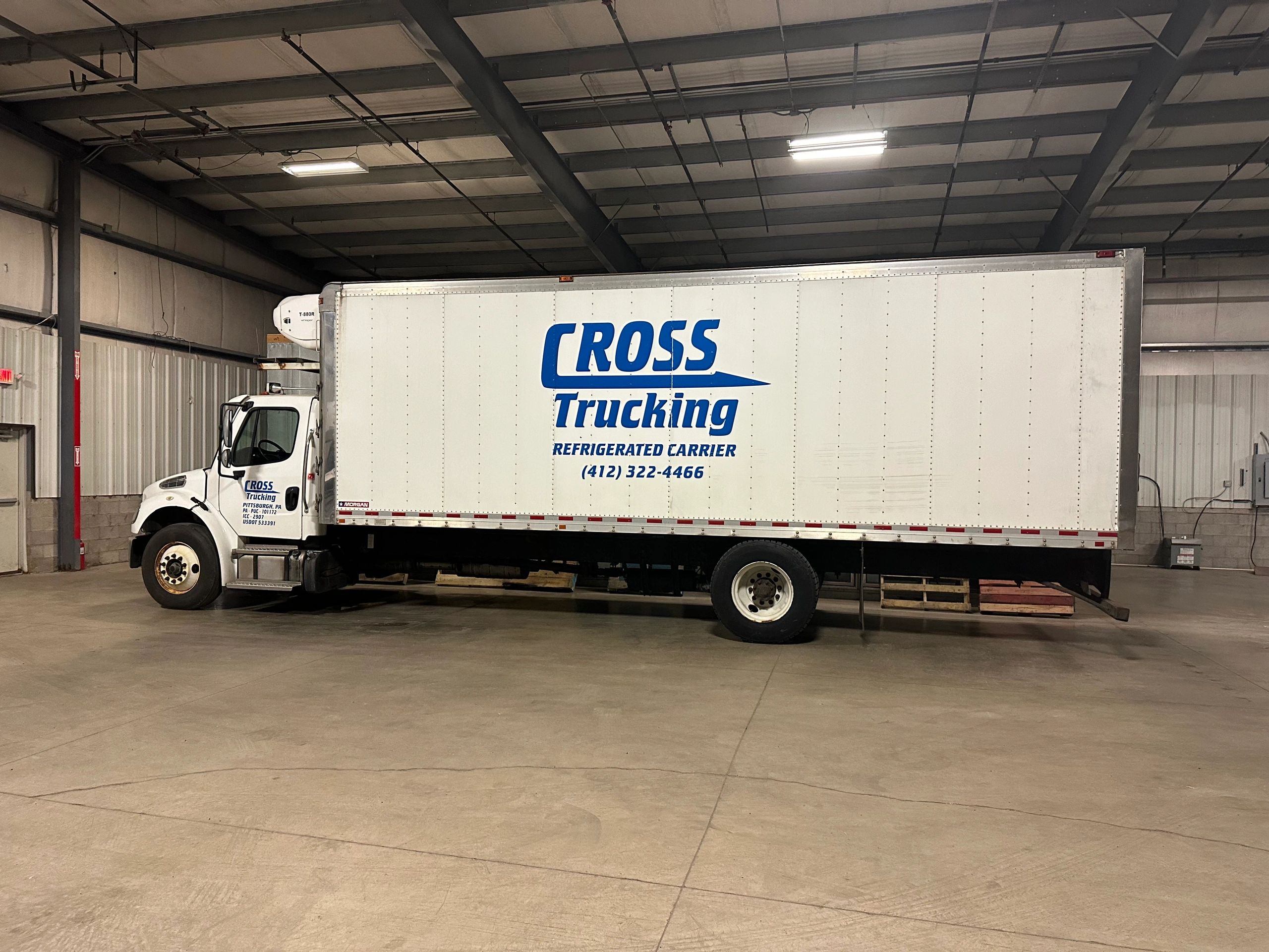 Refrigerator carrier truck parked at a den