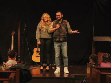 pastors lynna and paul on stage speaking