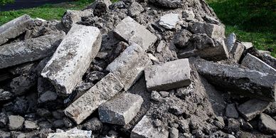 Pile of broken concrete rubble on the ground outdoors.