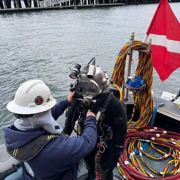 Diver assisted on boat preparing for underwater dive.