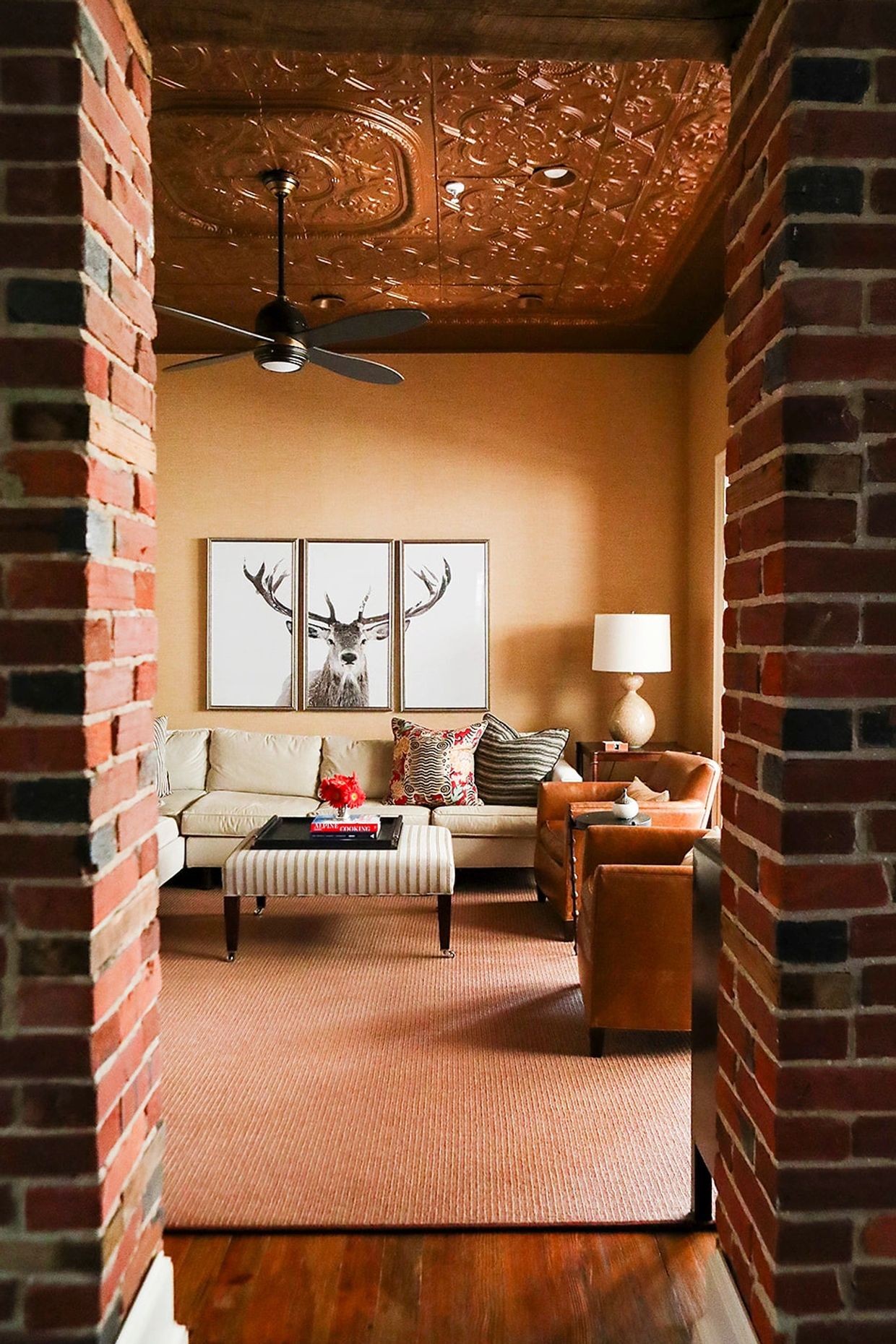 Family room with tin ceiling and grasscloth wallpaper