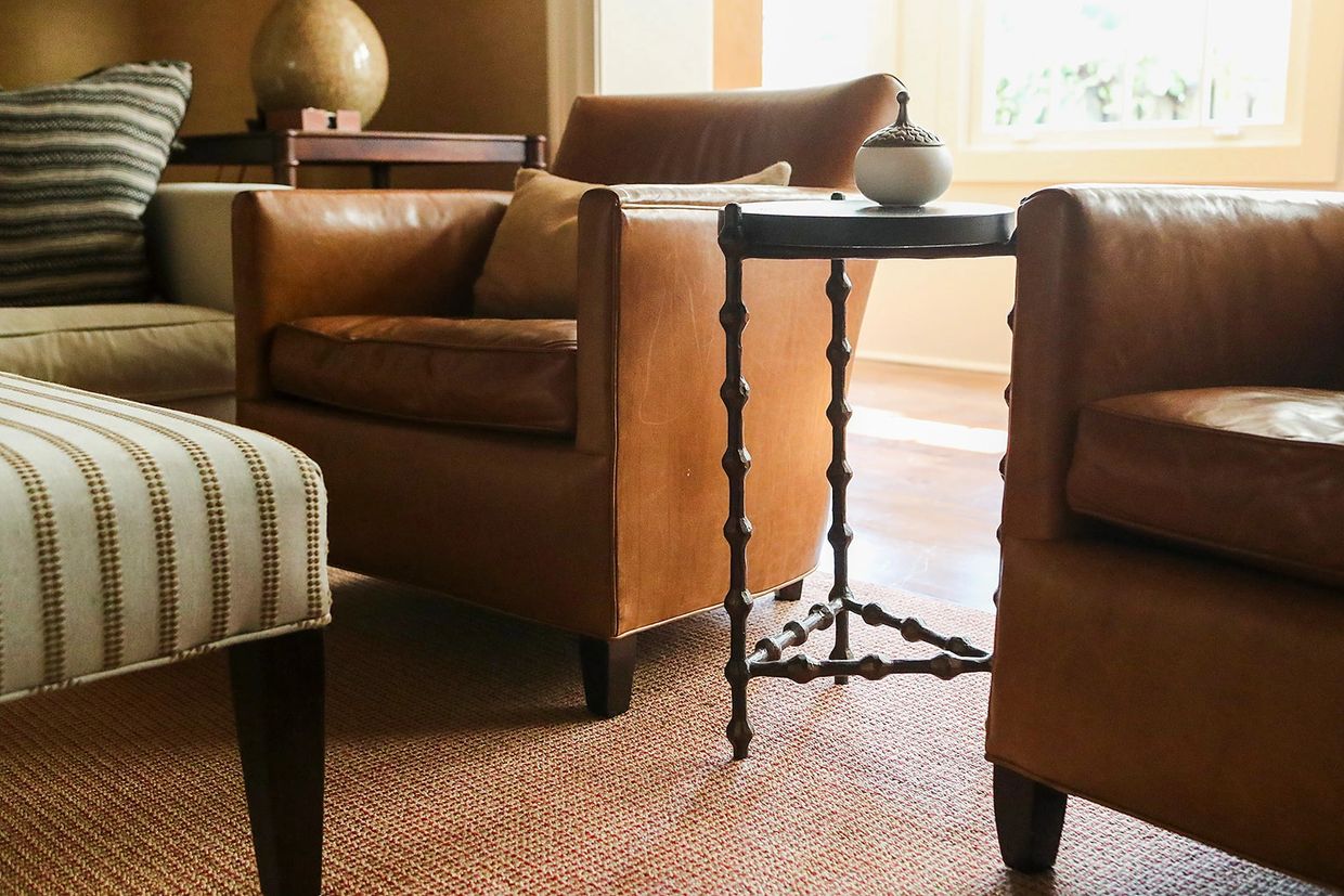Leather chairs and upholstered ottoman with iron side table