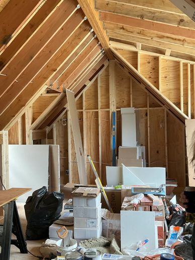 Renovation of new primary bedroom shows framing of new pitched ceiling
