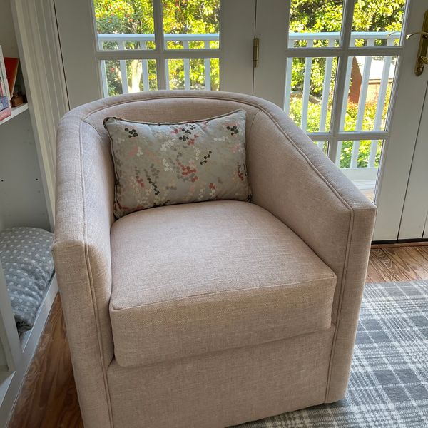Swivel chair with pink upholstery and silk pillow