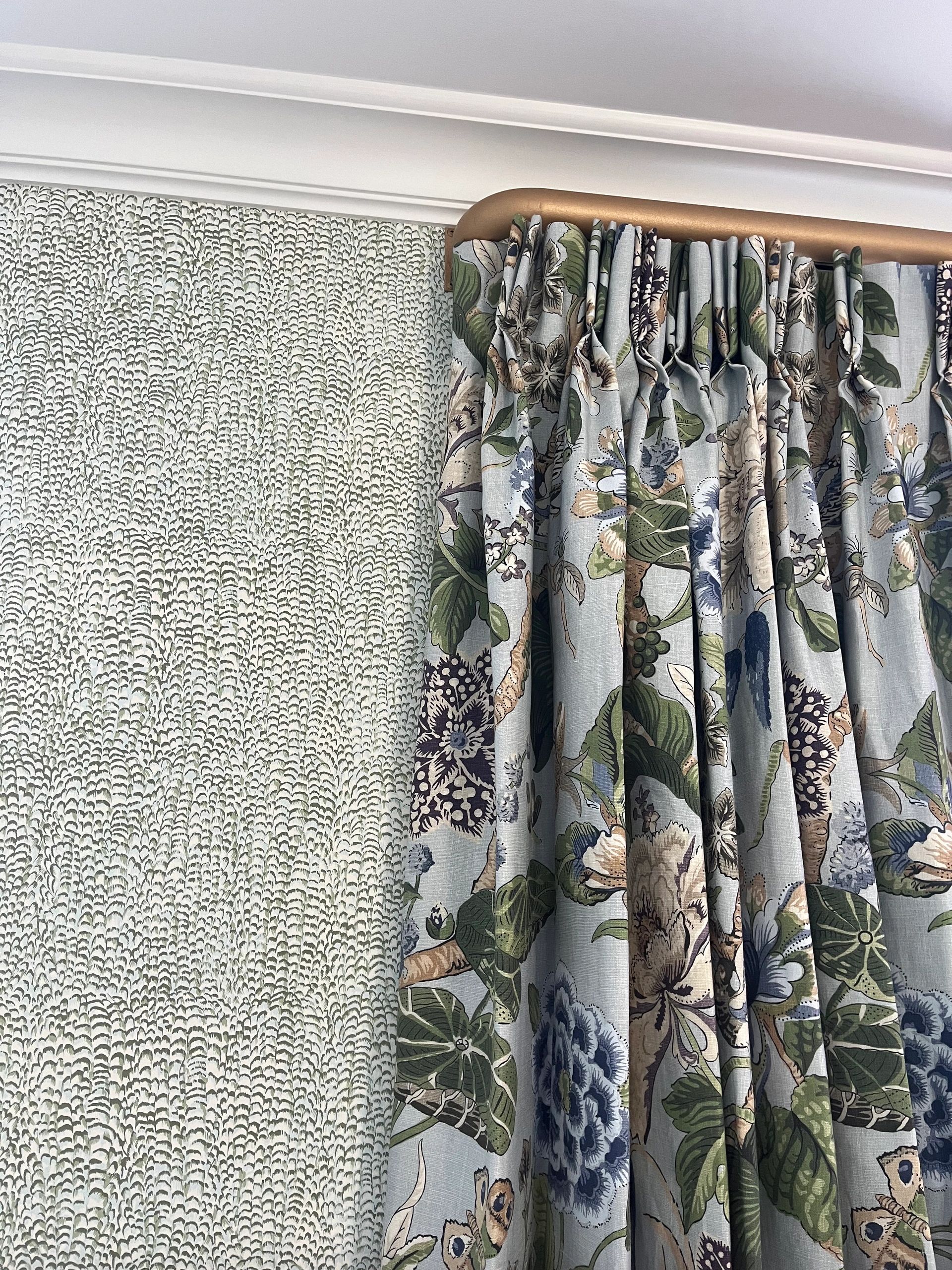 Pinch pleat drapery against wallpaper